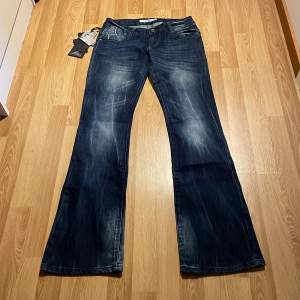(40) lågmidjade bootcut jeans med brodering på fickorna från lexxury. Helt nya med lappar kvar. Midjemått rakt över: 37 cm, innerbenslängd: 83 cm (massa stretch så passar större) 