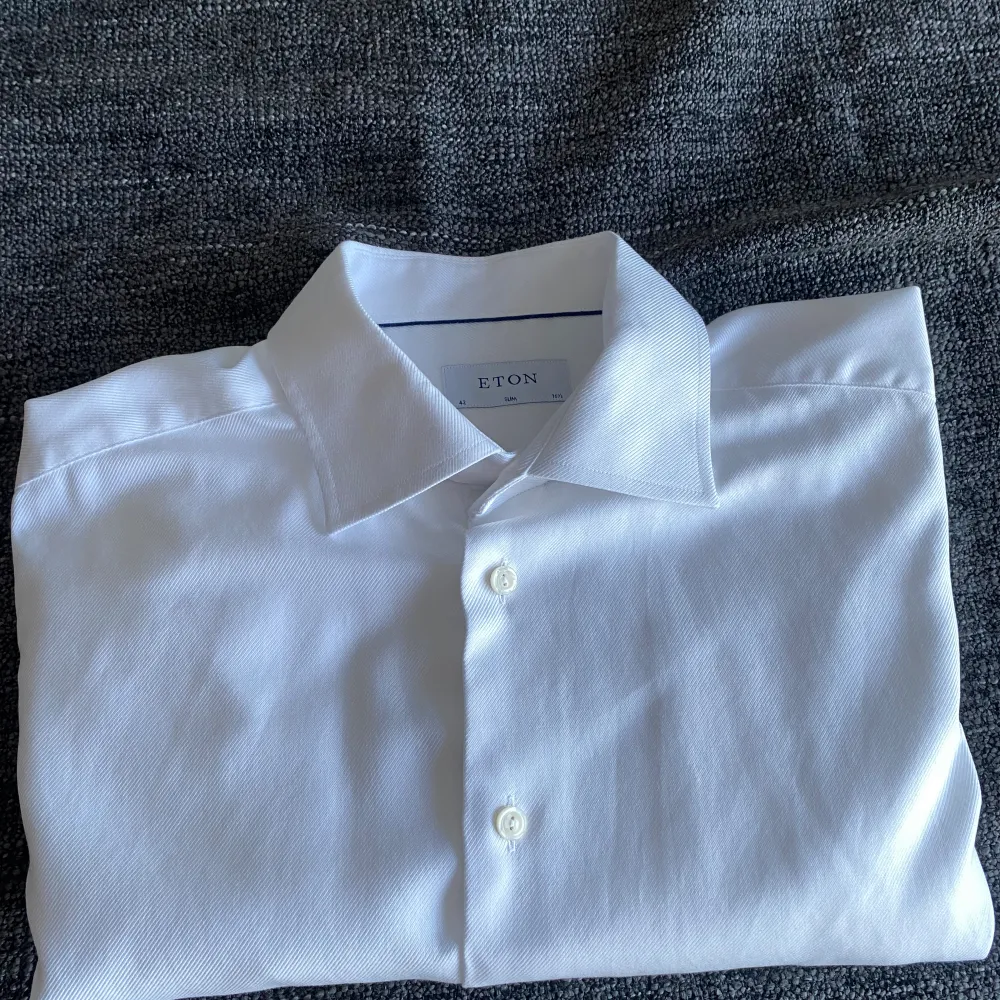 En jättefin vit skjorta från Eton i mycket bra skick. Det är en liten vit fläck på ryggen som syns på bilderna. Den syns dock inte när man har på sig den. Skriv för fler bilder. . Skjortor.