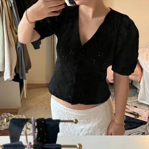 Svart blus  - Svart blus med puffärmar och mönster i tyget! Strl M 