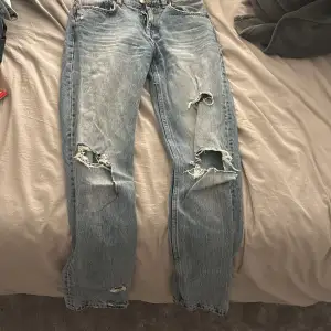 Blåa midwaist jeans med slitningar från zara. De passar på mig i längden på mig som är 170. Säljer för att jag inte använder de. Slitningarna längst ner på benet var så när jag köpte de. De är straight leg modell. 