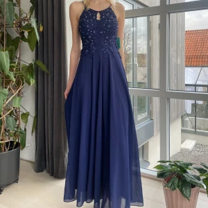 Mörkblå balklänning  - Superfin mörkblå balklänning. Den är helt oanvänd med prislappen kvar och inköpt för 1100 kr. Säljer då den är för kort för mig som är 180. Stretchig i midjan så storleken är flexibel. Hör gärna av dig om du vill ha fler bilder eller har frågor💞