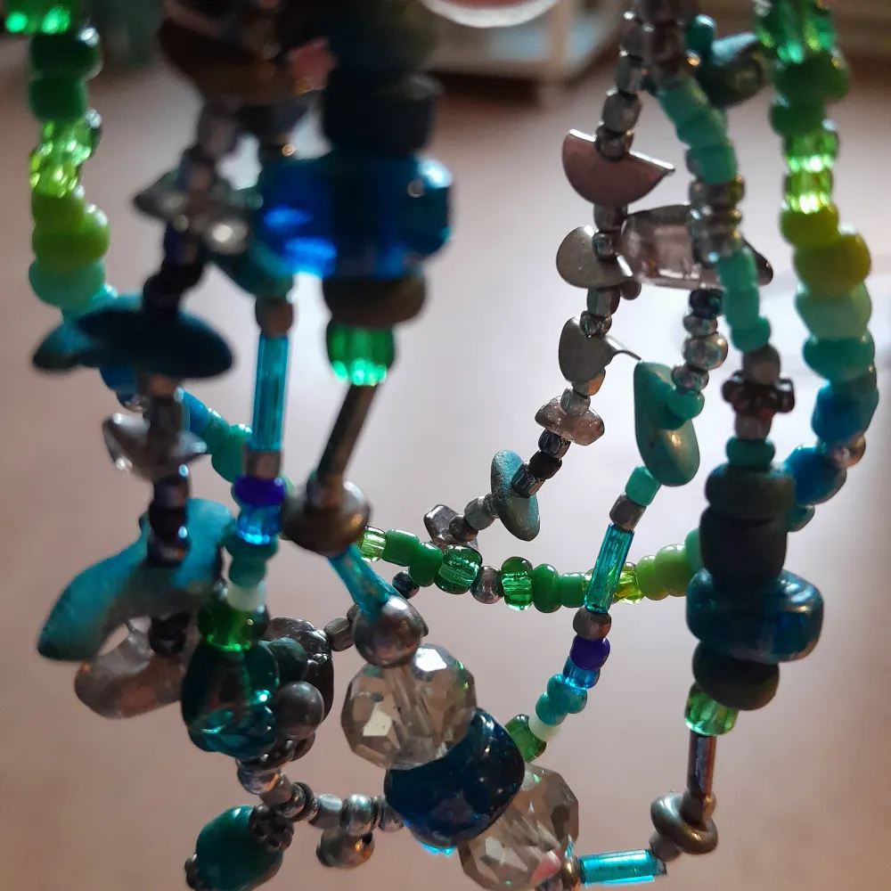 💚Ett armband med 4 rader, där färgerna går i grön/turkos/blå. 🩵Pärlor av glas, metall, trä, plast, kristall. 💙Q-lås, och går lätt att förlänga kedjan om nödvändigt. . Accessoarer.