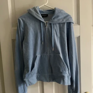 Juicy Couture set ljusblå - Säljer ett ljusblått Juicy Couture set i storlek M. Både koftan och byxorna är i fint skick. Säljes för 650kr som set. Annars 450kr styck.