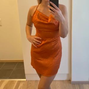 Orange klänning korsad rygg - Aldrig använd, minns ej vart köpt men skulle tippa på gina/bikbok/shein🥰(klipper alltid av lappar). Dovt mönster i orange färg. 