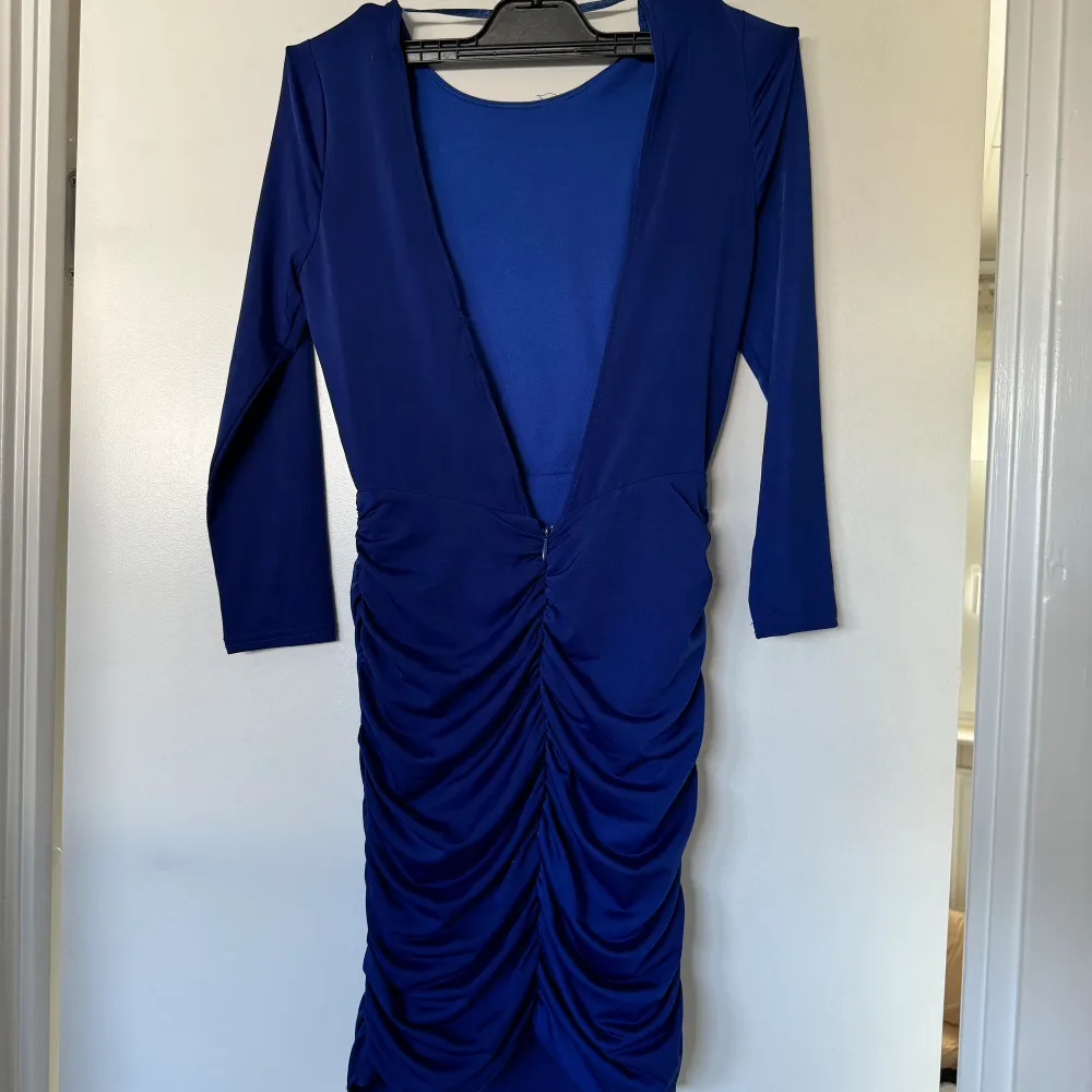 En blå mini festklänning med öppen rygg och drapering! Den är aldrig använd!. Klänningar.