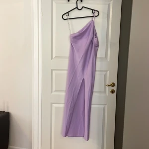 Enaxlad klänning  - Enaxlad klänning med drapering och slits från Asos. 