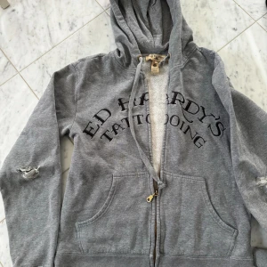 Ed Hardy Hoodie - Cool hoodie med tryck fram och bak, 80 % bomull, 20 % polyester, lite sliten vid armbågar och händerna men var så redan när jag köpte den second  hand 