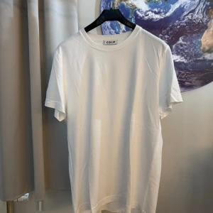 Vit t-shirt från CDLP - Säljer en snygg och enkel vit t-shirt från CDLP. Den är i nyskick och har en normal passform. Perfekt för både vardag och fest. T-shirten är gjord av mjuk och skön bomull, vilket gör den bekväm att bära hela dagen.