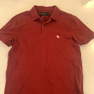 Abercrombie&fitch vinröd piké - Röd piké i galant skick. Nypris:314kr Säljs för endast 79kr