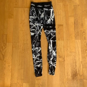Träningstights med marmormönster från Stronger - Träningstights från Stronger med marmormönster. Tightsen är i storlek XS och är i bra skick.