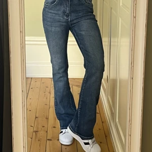 Bootcutjeans  - Bootcutjeans i snygg mellanblå tvätt och med dekorativa fickor bak. Något stretchiga och väldigt sköna. Stl M/38. Ca 35 cm rakt över, innerbenslängd 76 cm. 