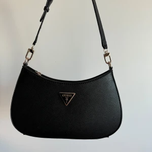 Guess väska  - Guess väska väldigt lite använd, ser inga fläckar eller skador på den. 