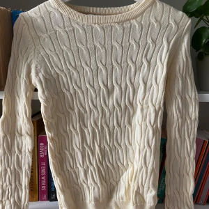 Beige stickad tröja från Morris Lady - Säljer en superfin beige/champange stickad tröja från Morris Lady. Den har ett snyggt flätmönster och är perfekt för både höst och vinter. Tröjan är långärmad och gjord av ett mjukt och bekvämt material. Passar perfekt till både jeans och kjol. Köp den nu och håll dig varm och stilren! 💫