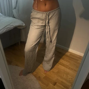 OLIVGRÖN LINNEBYXA - Säljer ett par superbekväma beige/ljusgrön linnebyxor med snörning i midjan. De är perfekta för en avslappnad look och passar både till vardags och mysiga hemmkvällar😌