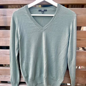 Uniqlo finstickad tröja i mjukaste ull  - Super härlig v-ringad pullover från Uniqlo i mjuk ull. Känns som kaschmir, härlig kvalitet! Knappt använd i mycket fint skick. Färgen är dovt grå/grön. Nypris 450:-