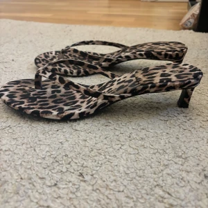 Leopardmönstrade sandaler med klack - Säljer ett par snygga leopardmönstrade sandaler med klack. De har en smal rem över foten och en liten klack som ger en elegant touch. Perfekta för sommaren och festliga tillfällen. De har endast används en gång därför i bra skick. 😍