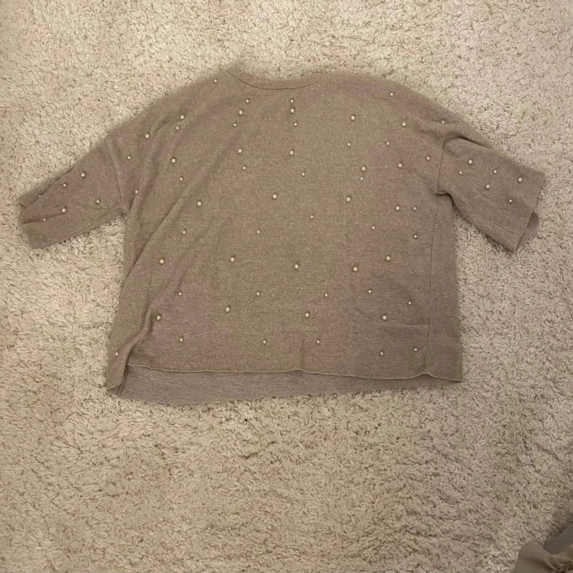 En beige tröja med pärlor - 91