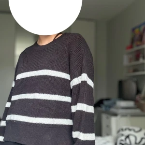 Svart och vit randig stickad tröja - Säljer en supermysig svart stickad tröja med vita ränder. Tröjan är till midjan ungefär och har långa ärmar. Perfekt för höst och vinter! Den är i bra skick och väldigt bekväm. Det är från Kappahl och köpt för ca 400kr