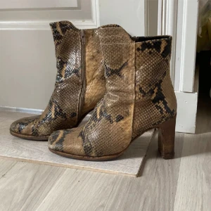 Ormskinn klack boots  -  Super snygga klack boots i äkta ormskinn! Jättefina i färgen och mönstret💋 Jättebra skick!