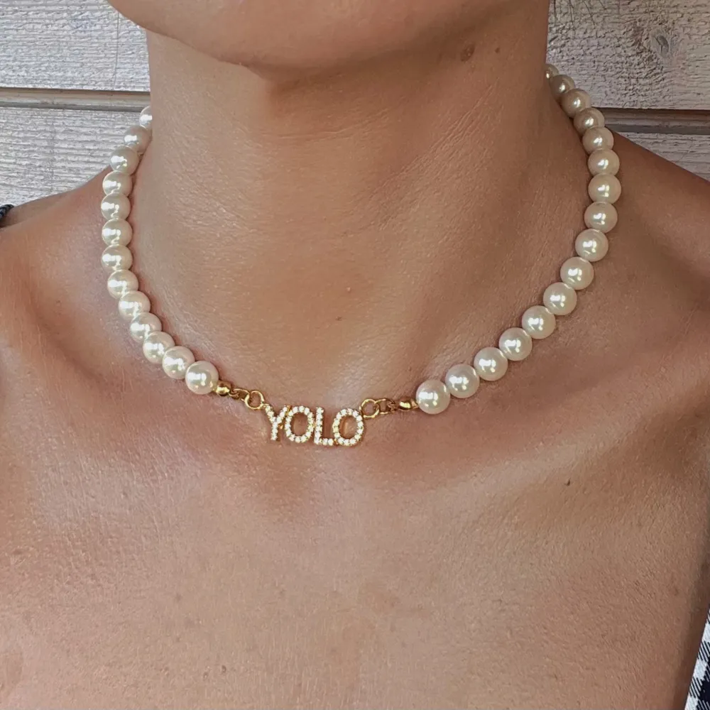 YOLO (you only live once) halsband med imiterade pärlor Material: Imiterade pärlor och rostfritt stål! Helt ny! Storlek:42 cm(justerbar). Accessoarer.