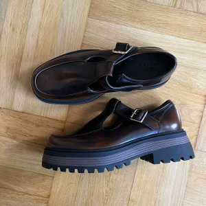 Fina skor! - Helt oanvända bruna fakeläder loafers med guldspänne i strl 42, men ganska stora storleken. Nypris är 539kr. Kan mötas upp i Malmö eller skickas :)