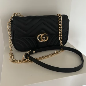 Axelremsväska - Superfin axelremsväska i läder med lagom utrymme samt supersnyggt långt band med guldiga ringar  