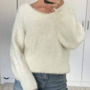 Stickad tröja  - Stickad fluffig tröja, så skön! Vit, lite urringad i ryggen med sömmar som drar ihop den lite, se sista bilden 