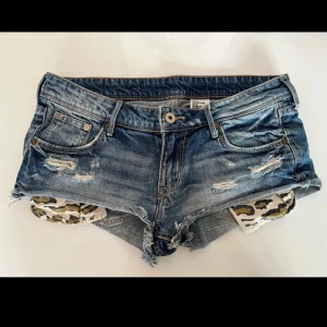 Lågmidjade jeansshorts  - Snygga lågmidjade jeansshorts, de vita under fickorna går att gömma eller ta bort, storlek 36. Midjemåttet är runt 38-39