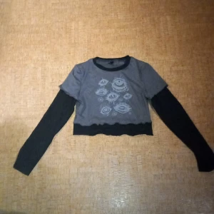 Grå tröja med ögon design - Har använts en gång, undertröjan sitter fast i övertröjan, kan inte tas bort.