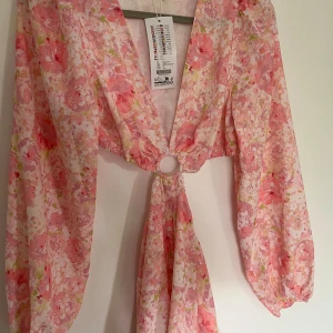 Blommig klänning med ” cut out” - Blommig klänning med ” cut out” för rygg/midja, oanvänd med prislapp kvar!  strl 38  Inköpt för 299kr på New Yorker