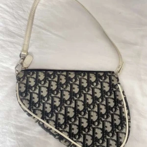 Dior väska  - Säljer min Dior vintage mini sadel klassisk grå/vit/svart monogram. Använd ett par gånger försiktigt! Väskan är i mycket bra skick. Köptes från vestiaire collective, kvitto finns!   Ingen dustbag ingår.