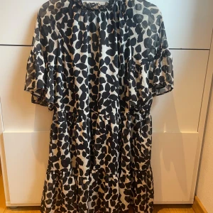 Mönstrad klänning - Mönstrad knälång klänning från H&M.  Använd några gånger men är i superfint skick.  Öppen rygg med två knyten. Passar XS-XL.