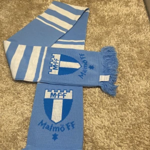En MFF halsduk med färgerna blå och vit  - Jag säljer denna då jag inte är ett MFF fan, aldrig använd, den är som ny då den inte  har kommit till användning! Köptes för 200 eller 250kr! Så jag säljer denna för 150kr och för en snabb affär 100kr! Köpare står för frakten. 