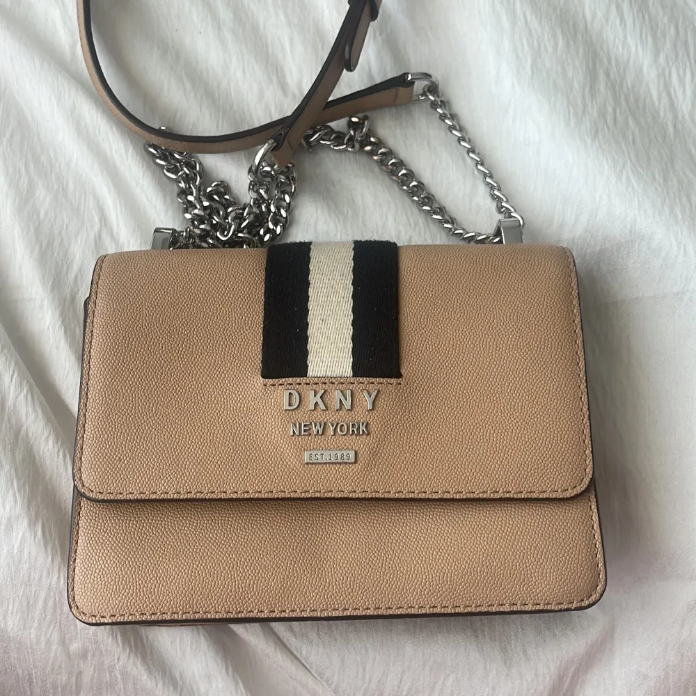 DKNY Väska köpt från Åhléns för ca 3000kr. Använd och kedjan har tappat färgen lite som ni kan se på bilden därav säljs den billigt. Laukut & Käsilaukut.