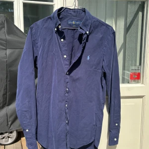 Ralph Lauren Skjorta - Mörkblå - Ralph Lauren skjorta i mycket bra skick, storlek S. Säljer pga vuxit ur den. Passar dig som är 170-180