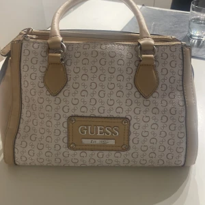 Guess väska  - En använd Guess väska. Har lite misfäringar och lite rost. Köpt för 1500. Pris kan alltid diskuteras. Lägg bara ett bud så svarar jag så snabbt som de går💖