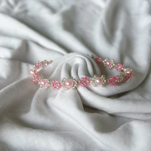 Rosa daisyarmband  - Handgjort armband med rosa blommor och silvriga/ljusrosa deltaljer. 