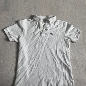 Fet lacoste piké  - Tjena👋🏼 säljer en Lacoste piké, den är vit färg och passar en 11 åring eller 10 åring. Den passar inte mig längre, bra skick😉 och använt en gång 😎😜 ny pris 739kr men har ingen lust att sälja dyrt ingen kommer köpa då
