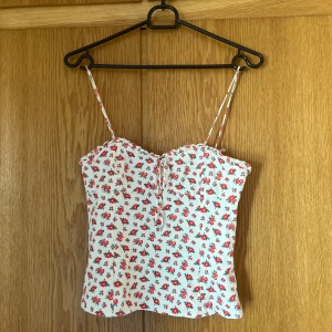 Sommar topp från Zara - Jättesöt unik blommig topp från zara. Köpt för några år sen och använd sparsamt. I väldigt bra skick. Lite korsettliknande med dragkedja som öppning. Sitter as snyggt men lite för liten för mig nu därav att jag säljer❤️ passar dig med lite mindre byst