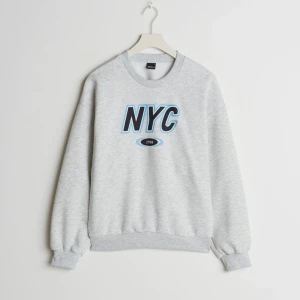 Sweatshirt från Gina Tricot - Sweatshirt med trycket NYC i storlek 40. Den sitter jättefint oversized på mig som vanligtvis bär storlek 36. Aldrig använd och inga defekter. Jättemjukt material 💗