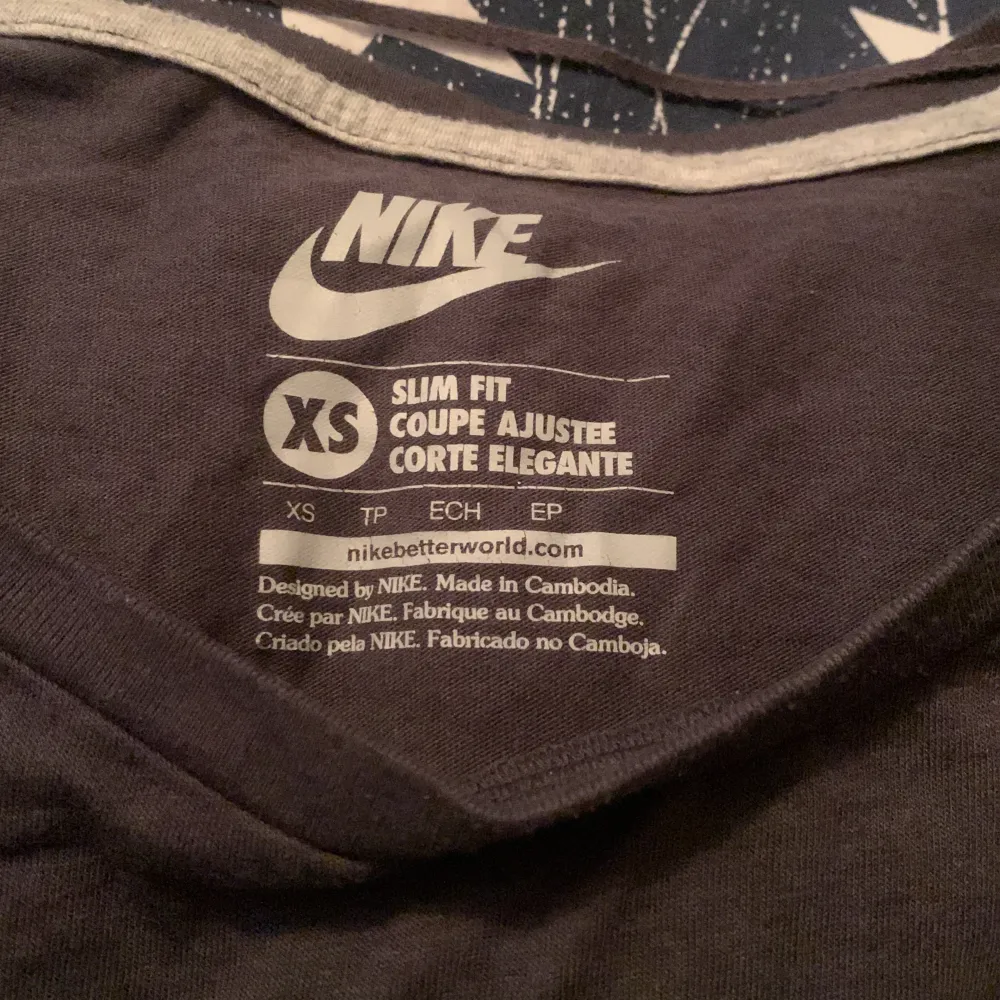 En Nike T-shirt/träningströja, lite grå svart färg med lime grön färg, strlk XS men passar mig som har M . T-shirts.