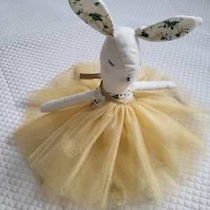 Handgjord Tilu Lilu kanin,mjuk leksak för Påskpresent - Storlek: H 40 cm Färg: Beige Material: Bomull och tyll  Fyllning: Polyester silikonfyllning Underhåll: De kan rengöras med mild tvål och vatten. Ögon och näsa är handbroderade,armar och ben rör sig och alla kläder och accessories är avtagbara.