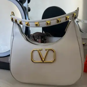 Super snygg väska ifrån Valentino. Vit med guld detaljer. Liten skrapa på skinnet av väskan. Skriv för fler bilder!