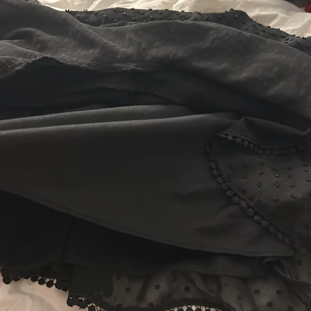 En svart gullig volang kjol med prickar på, den har ett till lager under volangerna så väldigt säker kjol. Väldigt bra skick och har inte alls använts mycket . . Kjolar.