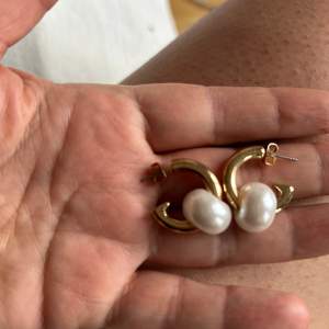 Guldiga örhängen med pärla 