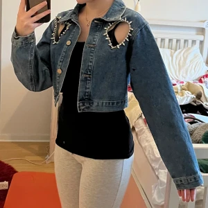 Unik Jeansjacka  - En kort jeansjacka med hjärtformade utklippningar. Aldrig använd och helt ny.  Väldigt fin och unik tycker jag, men säljer eftersom det inte passar min stil. Kan vara åt de mindre hållet i storleken. 