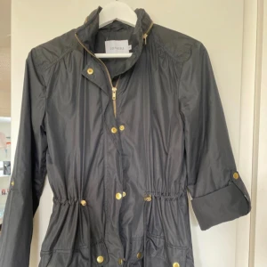 Trenchcoat / kappa - Tunn trenchcoat med många detaljer