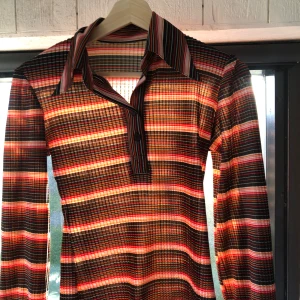 Retro blus - Vacker blus från 70 talet🧡Rosa,svart och röd randig i ett unikt material där det är vilt i ett vågigt mönster vilket gör det stretchigt🫶🏼Hör av dig vid frågor🧡🧡