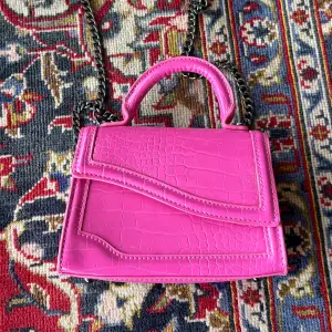 Väska med axelrem med kedja. Snygg color pop i rosa.