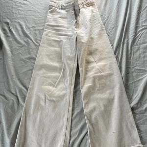 Vita breda jeans - Ett par snygga breda jeans från Zara i vit färg. Storlek W34 med midjemått på ungefär 32cm samt innerbenslängd 66cm. Kontakta för funderingar eller pris!